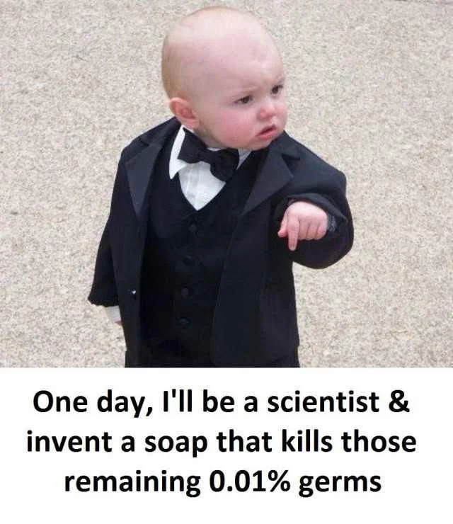 001 Of Germs — A baby in formal tuxedo attire and bow tie pointing with determination, with text about becoming a scientist to kill the remaining 0.01% germs.