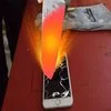 1000 Degree Knife Videos — A red-hot glowing knife cuts through a smartphone, demonstrating extreme heat with bright orange and red coloring.