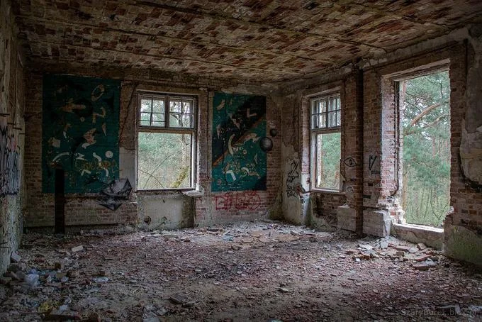 11B X 1371 — Photograph of an abandoned interior space with peeling brick walls, boarded windows, and severe deterioration.