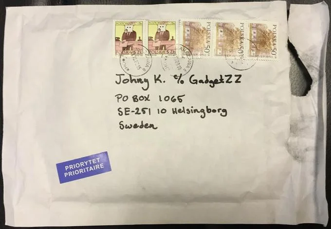 11B X 1371 — Priority mail envelope addressed to Johnny K. in Sweden with multiple postage stamps, reflecting the mysterious mailing aspect.