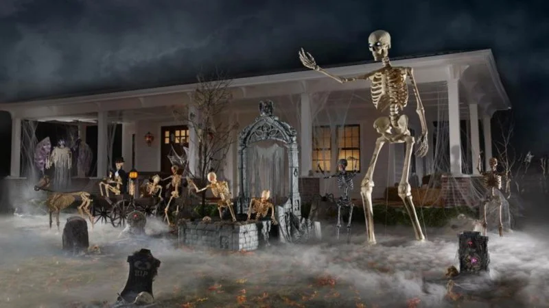 12 Foot Tall Home Depot Skeleton — Professional rendering of the 12-foot Home Depot skeleton prominently displayed with Halloween decorations, fog, and