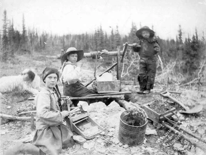 120 Year Old Greta Thunberg — Black and white archival photograph from circa 1898 showing three children operating mining equipment at Dominion Creek, Yukon