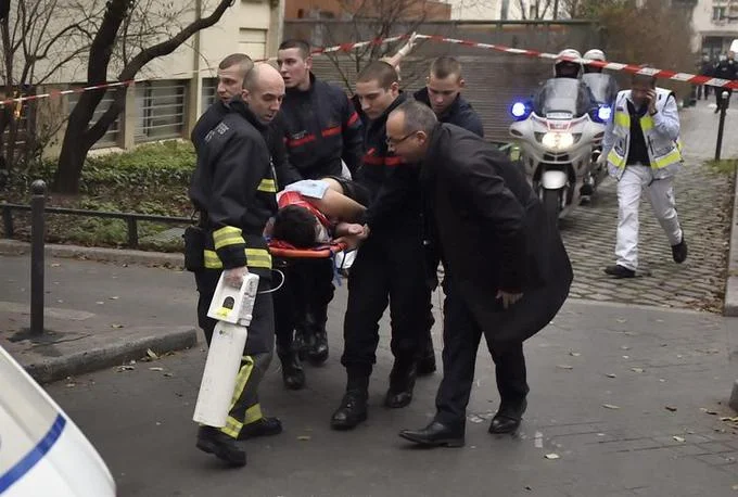 2015 Charlie Hebdo Terrorist Attack — Paris firefighters evacuating a wounded victim on a stretcher after Charlie Hebdo attack
