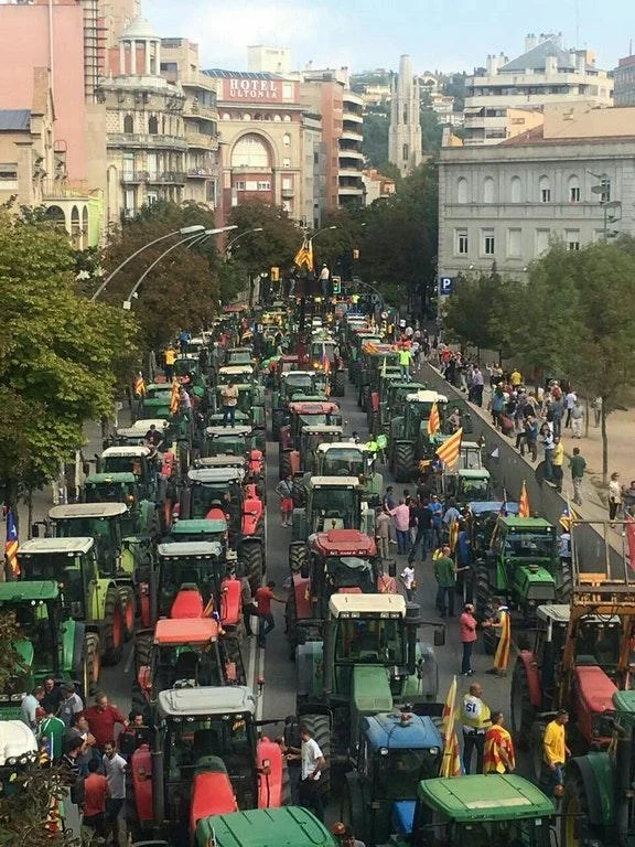 2017 Catalan Independence Referendum — Line of tractors and demonstrators with Catalan flags in a Girona street protest