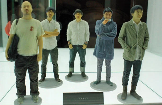 3D Printing — Five full-color 3D-printed figurines of men in casual clothing in a display case