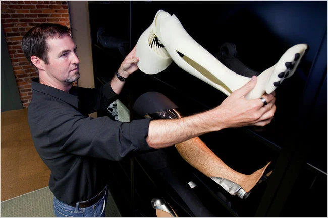 3D Printing — Man holding a large white 3D-printed prosthetic or fashion piece in a studio