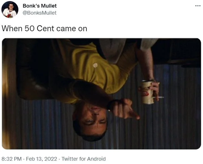 50 Cent Hanging Upside Down — Person in yellow outfit positioned upside down as reaction to 50 Cent's arrival.