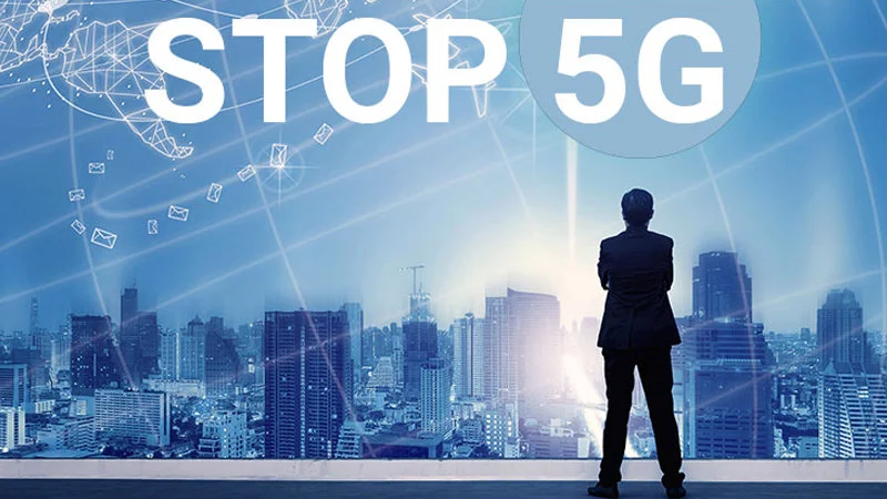 5G Conspiracy Theories — A conceptual image showing a silhouetted businessman overlooking a futuristic digital cityscape with network imagery and bold 'STOP