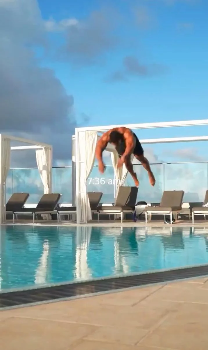 736 Pool Dive — Vertical shot of muscular man mid-dive above pool with 7:36 am timestamp visible