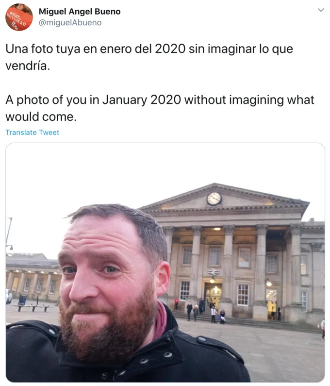 A Photo Of You In January 2020 Without Imagining What Would Come — Tweet screenshot of a bearded man taking a selfie outside a classical station building