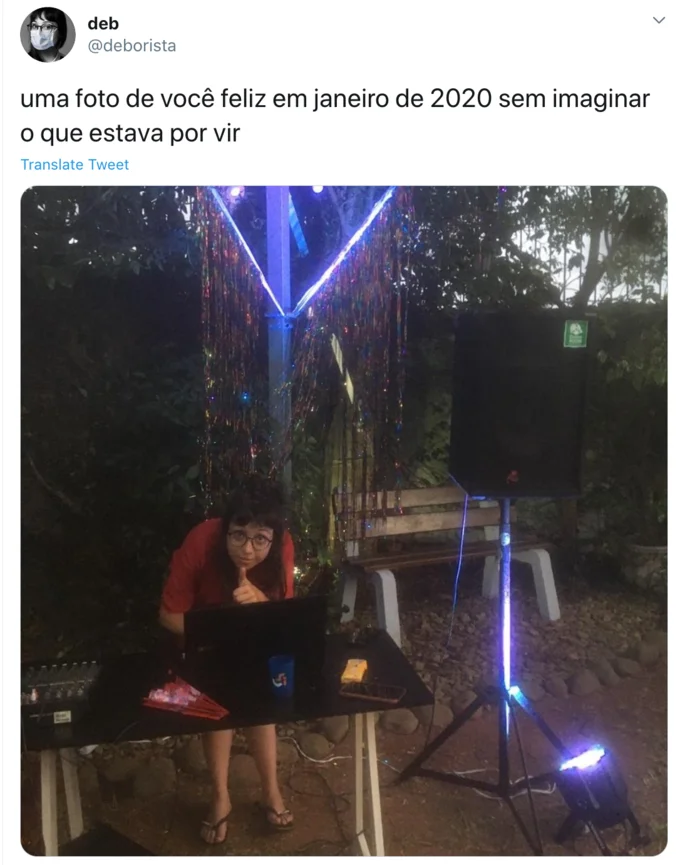 A Photo Of You In January 2020 Without Imagining What Would Come — Tweet screenshot of a person DJing outdoors in front of a tinsel curtain