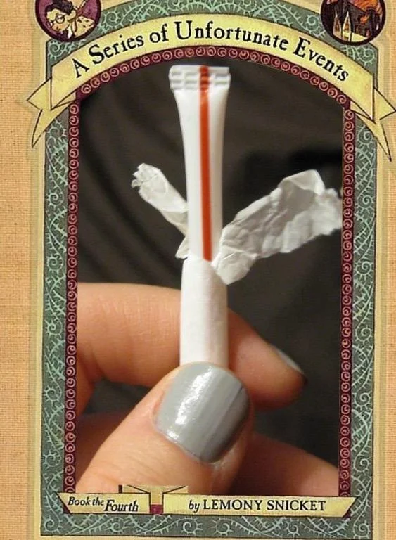 A Series Of Unfortunate Events Cover Parodies — Duplicate cover parody with razor wrapped in tissue held in a hand