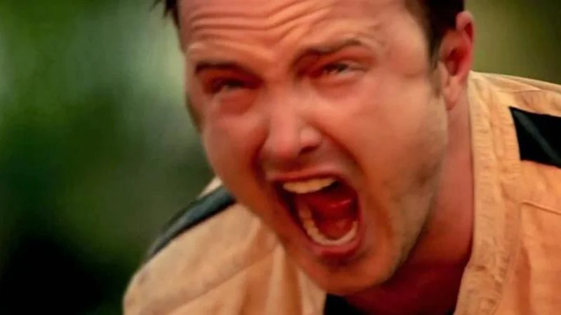 Aaron Paul Screaming — Aaron Paul as Jesse Pinkman screaming with mouth wide open in a tan jacket outdoors