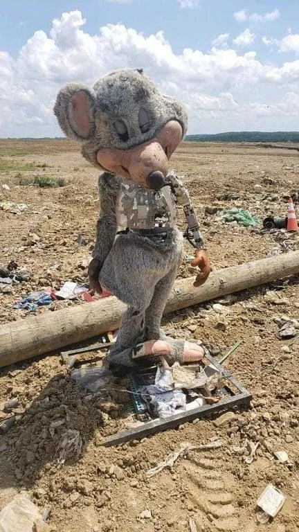 Abandoned Chuck E Cheese Animatronic — Abandoned Chuck E. Cheese mouse animatronic standing amid landfill debris