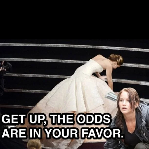 Academy Awards — Meme of Jennifer Lawrence fallen at Oscars with Katniss saying Get Up The Odds Are In Your Favor