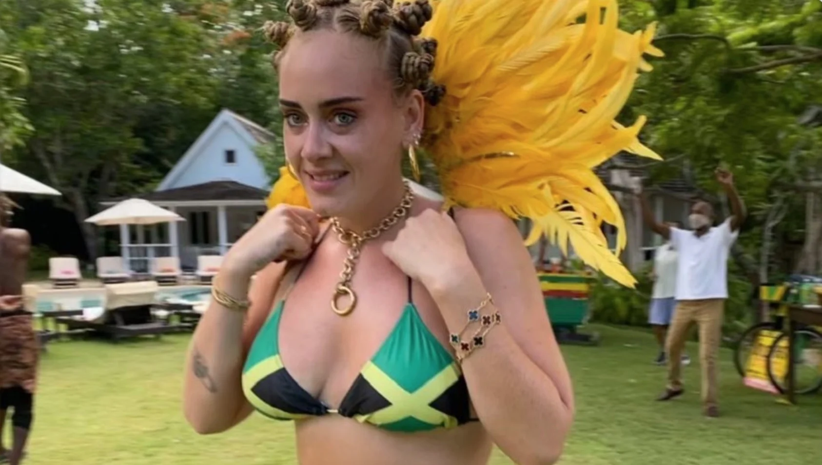 Adele's Notting Hill Carnival Photo — Adele in Jamaican flag bikini top with Bantu knots and yellow feathered carnival wings outdoors
