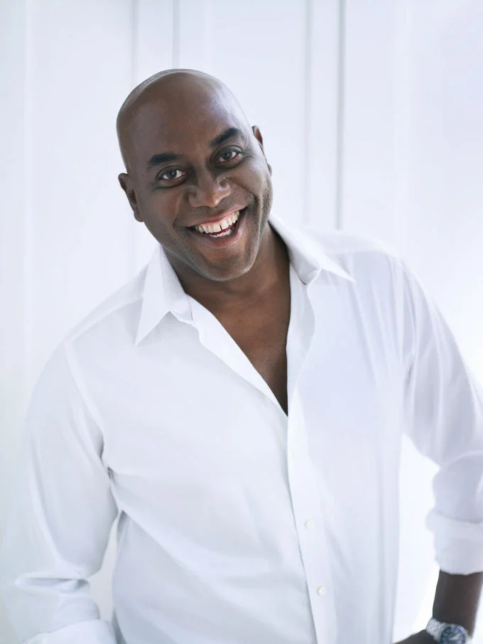 Studio portrait of Ainsley Harriott smiling in a white shirt