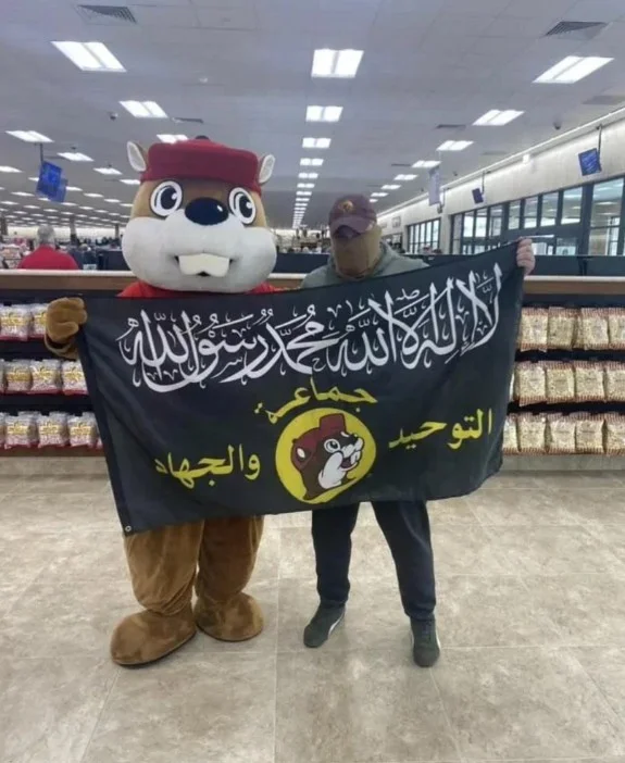 Al Buqqi — Buc-ee's beaver mascot posing with a person holding the al-Buqqi flag inside a store
