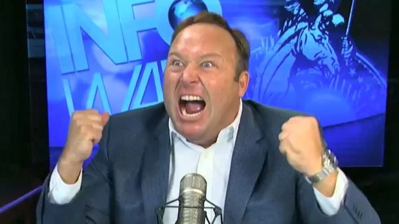 Alex Jones yelling with fists raised on the Infowars set