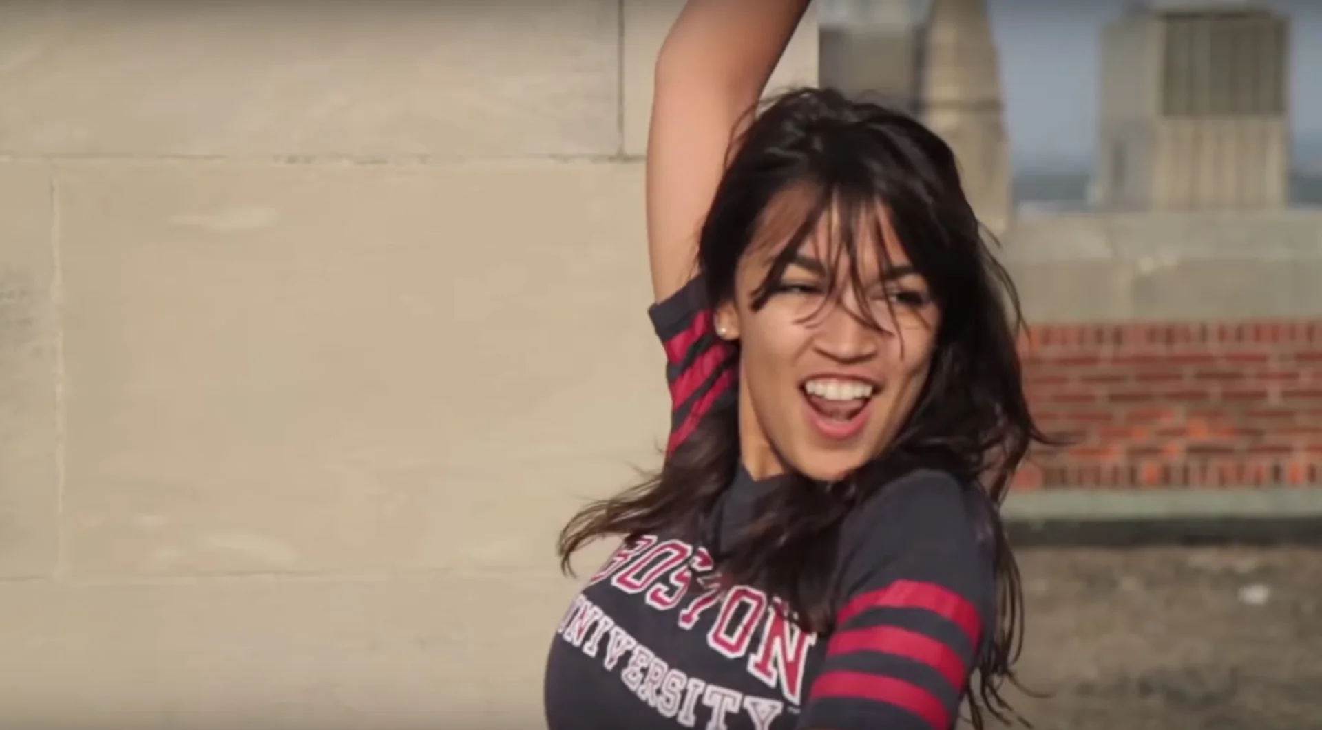 Alexandria Ocasio Cortez Breakfast Club Dance Video — Alexandria Ocasio-Cortez dancing on a rooftop in a Boston University shirt