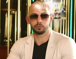 Andrew Tate Memes — Professional portrait of Andrew Tate wearing sunglasses, light jacket, and black shirt.