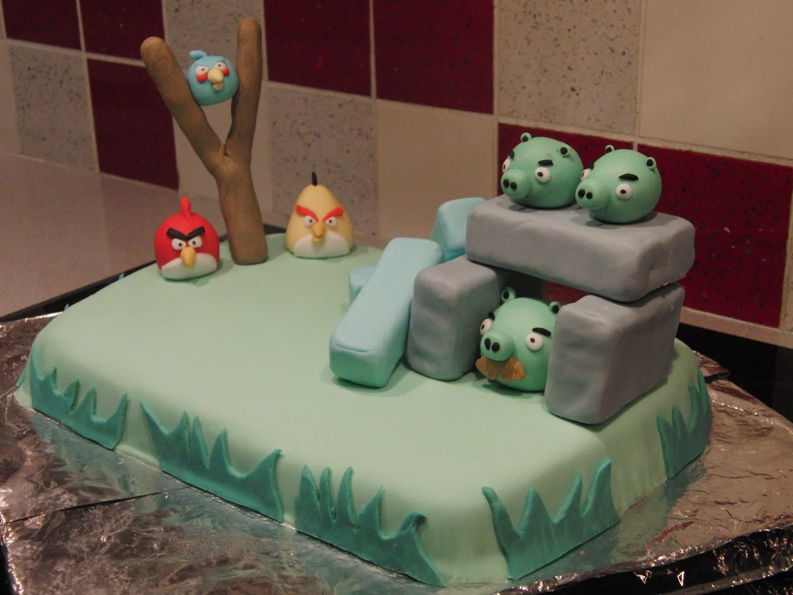 Angry Birds themed fondant cake with bird and pig figurines