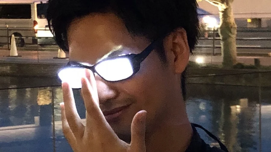 Anime Glasses — Man with glasses reflecting bright white light hiding his eyes, mimicking anime character
