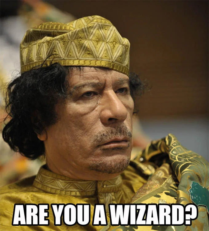Muammar Gaddafi in gold robes captioned ARE YOU A WIZARD