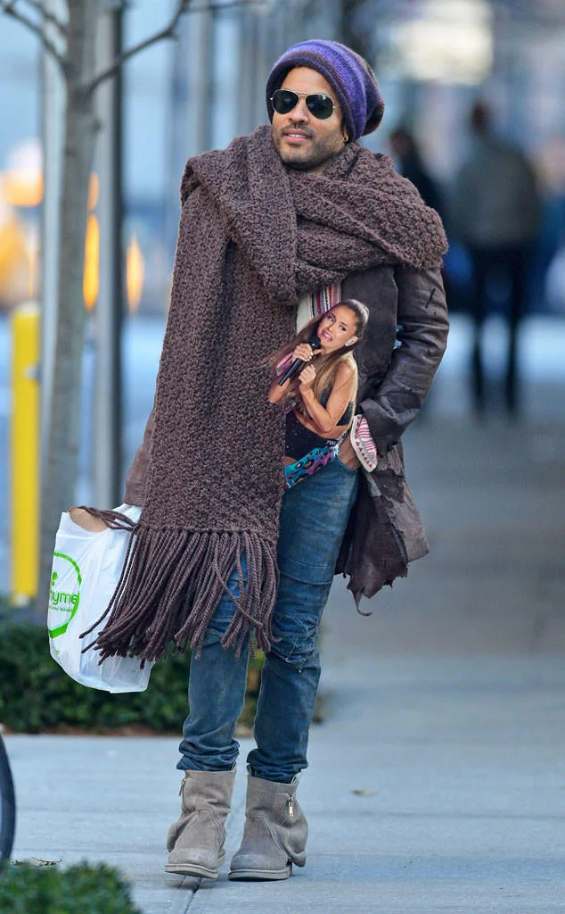 Lenny Kravitz in giant scarf with photoshopped Ariana Grande cutout tucked in coat