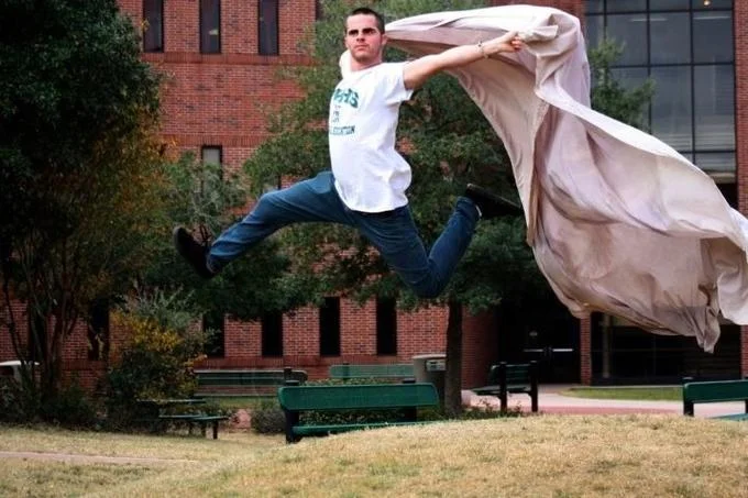 As Fuck Af — Man leaping mid-air with a flowing cape-like sheet