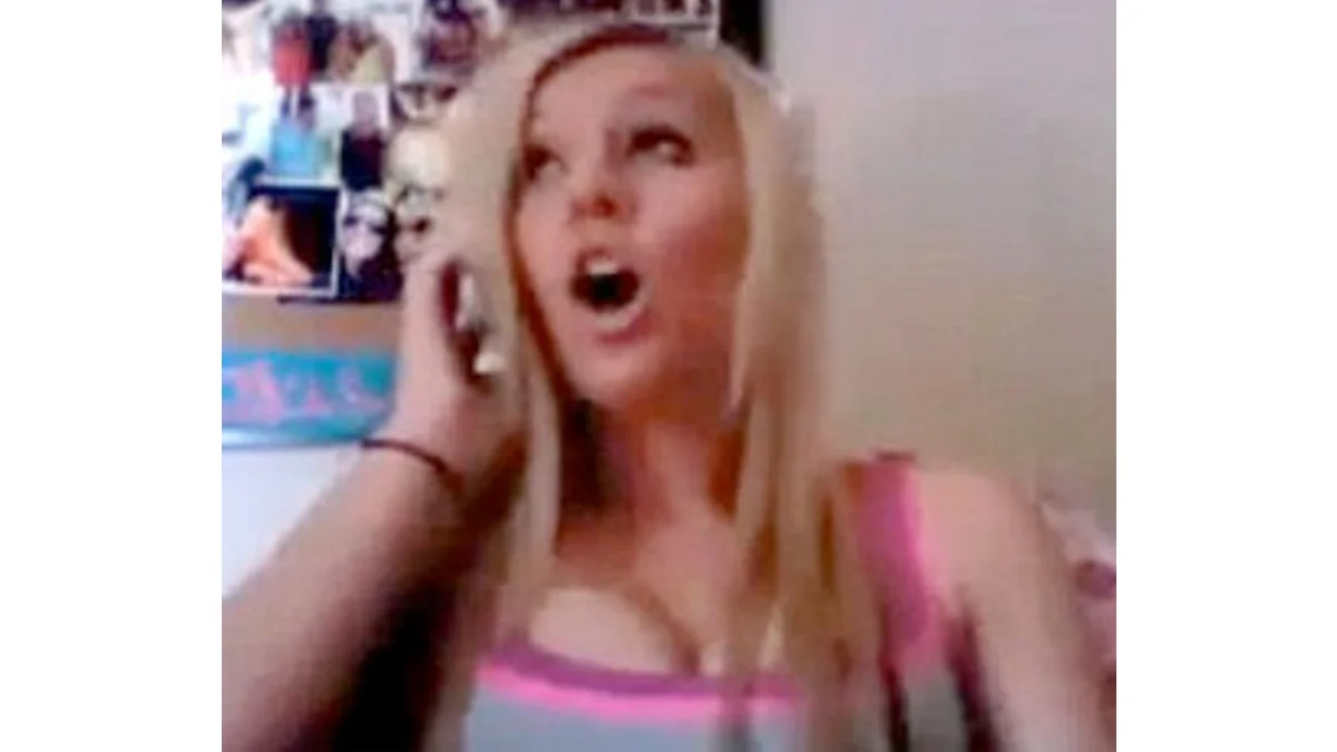 Asians In The Library — Blonde girl with open mouth holding phone in webcam-style shot