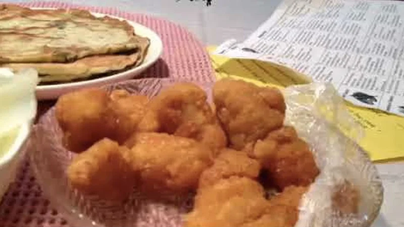 Awesome Popcorn Chicken — Bowl of fried popcorn chicken on pink placemat with scallion pancakes on the side