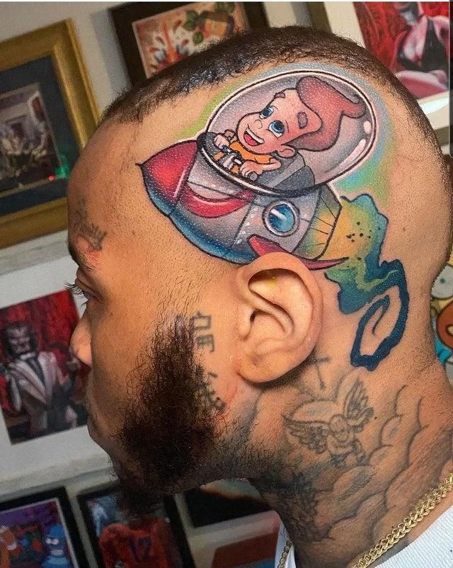 Awful Taste, But Great Execution — Colorful cartoon baby in a rocket ship tattoo on a man's shaved head