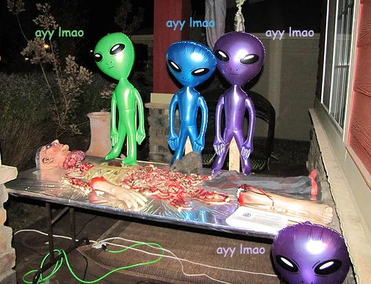 Colorful inflatable aliens around a fake body with 'ayy lmao' captions