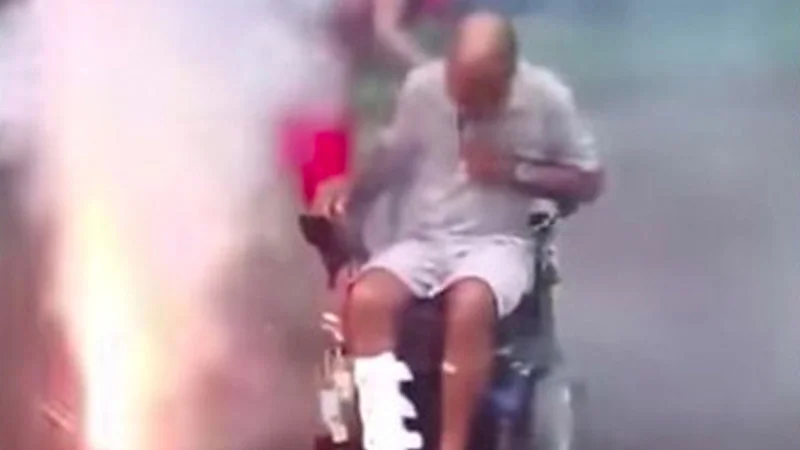 Back Up Terry Put It In Reverse Terry — Man in wheelchair surrounded by exploding fireworks with bright sparks and smoke.