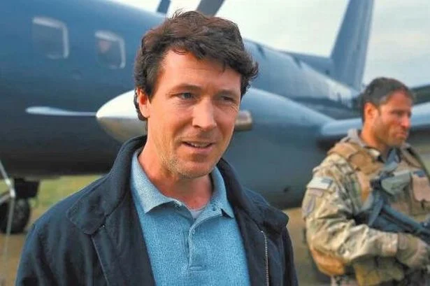 Baneposting — Casual photograph of actor with military personnel and plane in background.