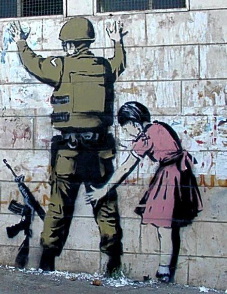 Banksy mural of a little girl frisking a soldier