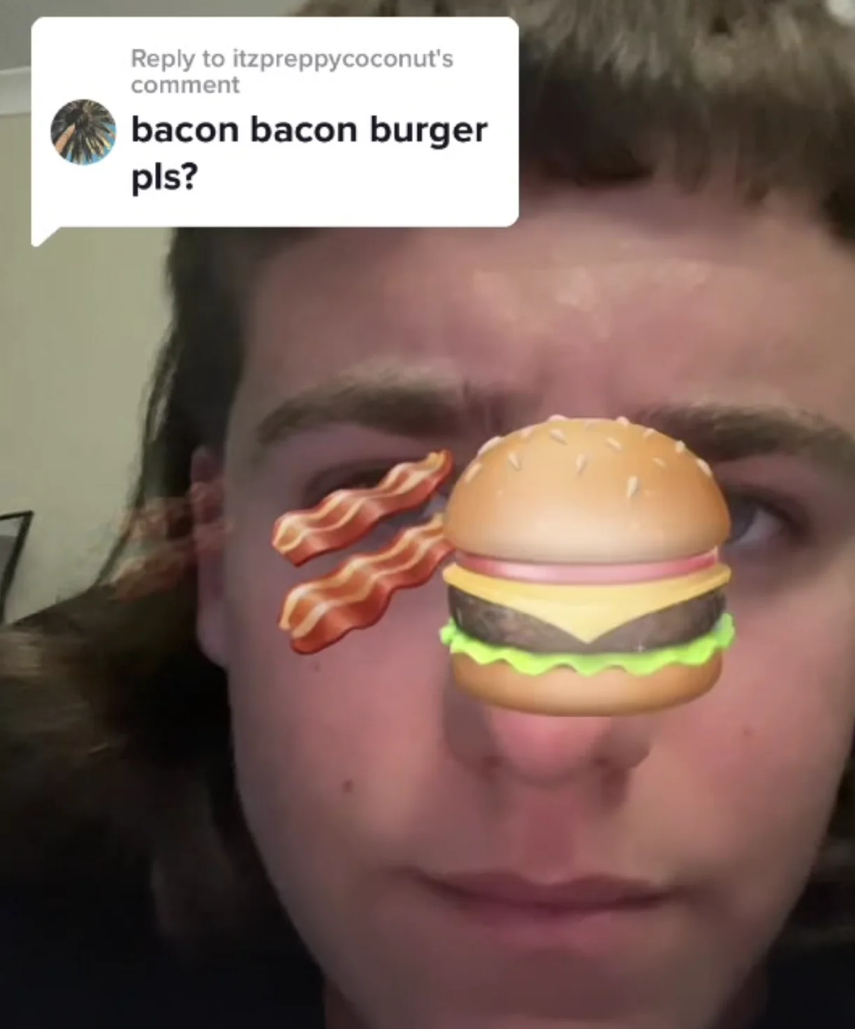 Barbeque Bacon Burger (TikTok Challenge) — TikTok screenshot of a young man with bacon and cheeseburger emoji on his face, replying to a comment asking 'bacon
