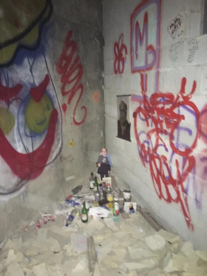 Bathroom Shrines — Bathroom shrine corner with cutout figure and colorful graffiti artwork.
