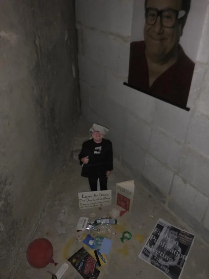 Bathroom Shrines — Bathroom corner shrine with large Danny DeVito cutout and memorial-style floor display.