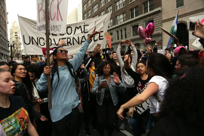Street protesters carrying a 'Become Ungovernable' banner
