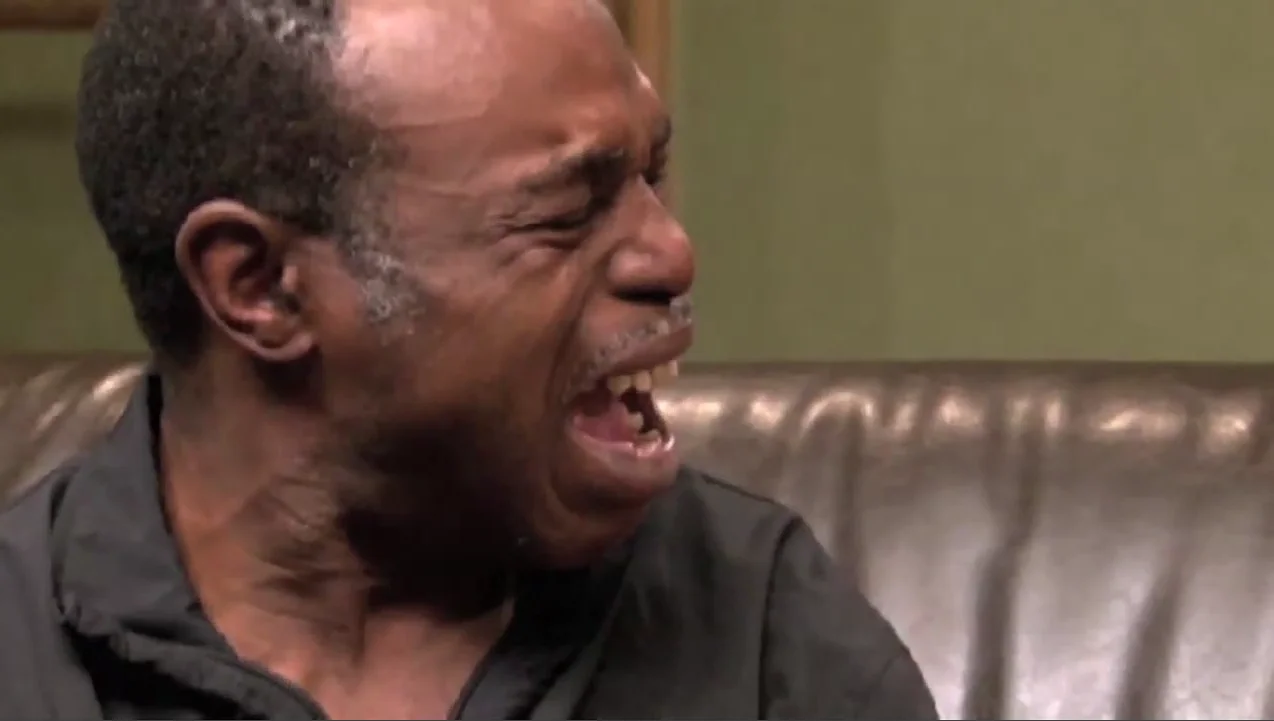 Best Cry Ever — Middle-aged man on a leather couch crying with his mouth wide open