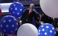 Bill Clinton Loves Balloons — Bill Clinton stands beaming amid a cluster of large blue star-decorated balloons at the 2016 Democratic National Convention, with