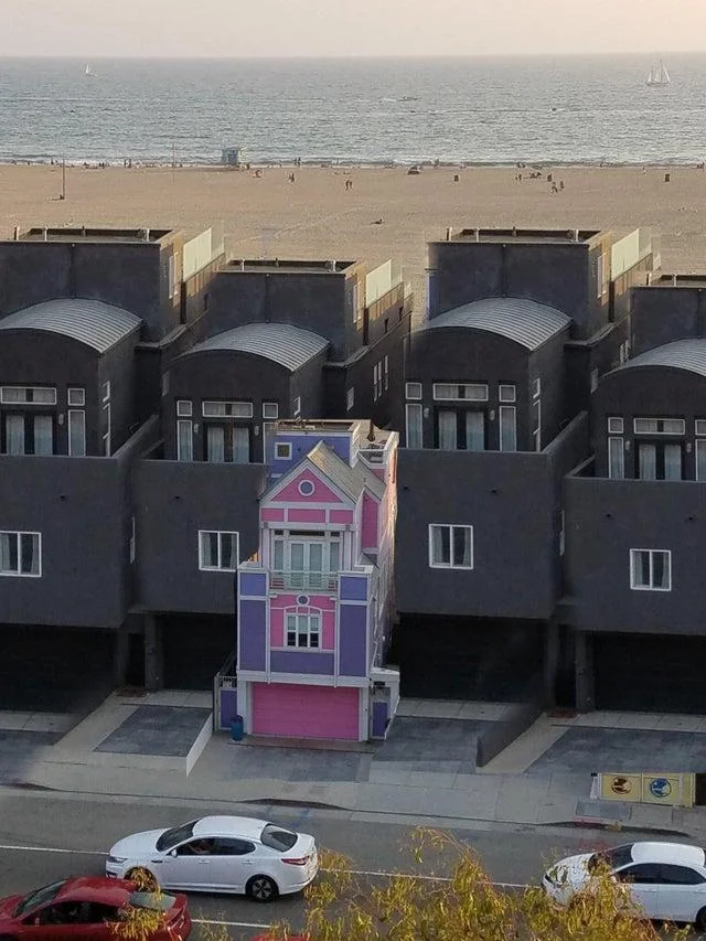 Black and Pink Meme Houses — Pink Victorian house among row of dark gray beach homes