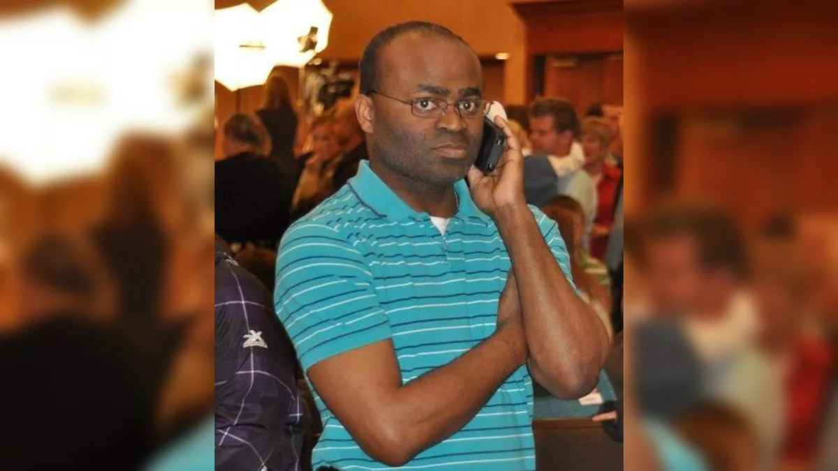 Black Guy On The Phone — Bald Black man with glasses in teal striped polo shirt holding phone to ear with a skeptical sideways glance