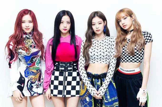 BLACKPINK members posing in colorful streetwear outfits against a white background