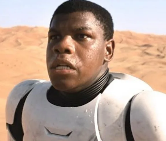 Blackstormtrooper — John Boyega as Finn in stormtrooper armor standing in a desert