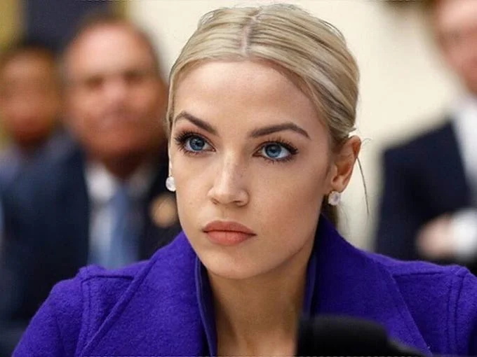 Blonde AOC — Cropped portrait of the blonde-haired, blue-eyed AOC edit in a purple blazer.