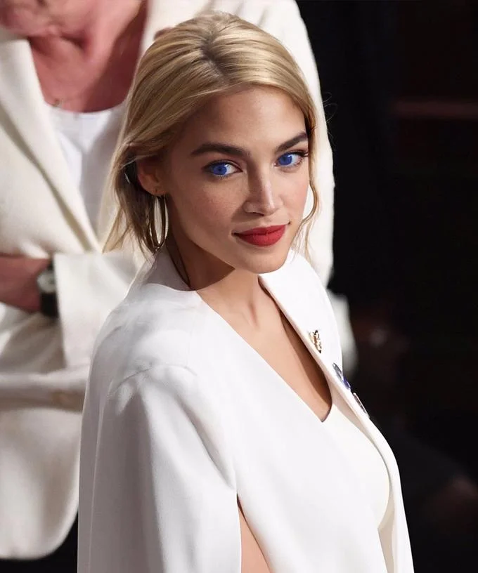Blonde AOC — AOC digitally altered with blonde hair and blue eyes wearing a white cape blazer.