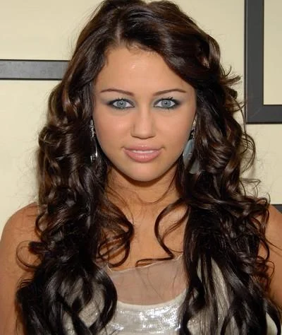 Blue Eyes Slander — Miley Cyrus with pale blue eyes and heavy eye makeup at a red carpet event.